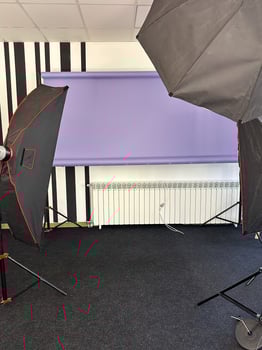Professional photography studio setup with lighting equipment and a purple backdrop. the studio is well-equipped and ready for a photo session or recording