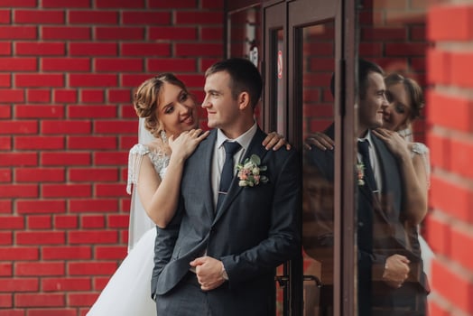 A man and woman are standing in front of a brick building photo