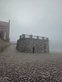 a person standing on a stone path in the fog photo