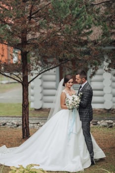 A bride and groom are standing in front of a tree photo
