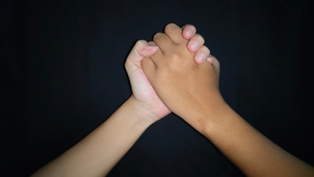 Two hands shaking which means friendship.Isolated on black background photo