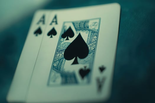 A close-up view of the ace of spades card rests on a solid background, emphasizing its intricate details and iconic suit symbol. The sharp focus highlights the cards design. photo