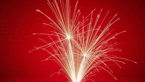 Fireworks illuminate against a striking red backdrop photo