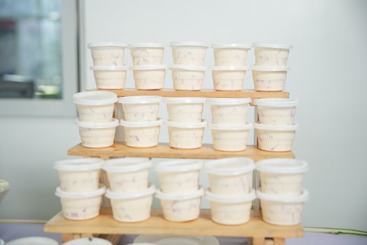 A wooden stand with many containers of food photo