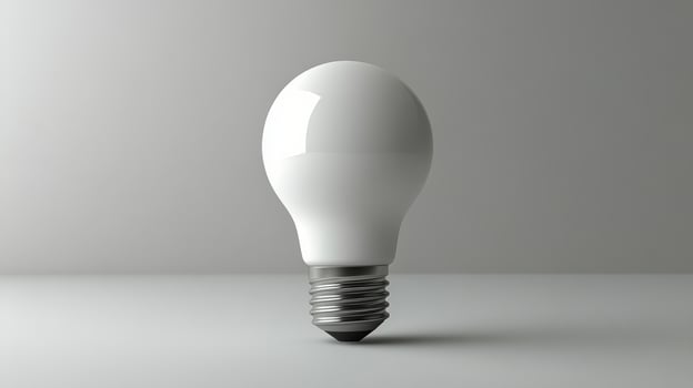 White light bulb resting on a smooth surface in a minimalist setting with soft lighting photo