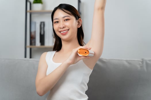 A beautiful woman is epilating her armpits using an IPL laser hair removal epilator device photo