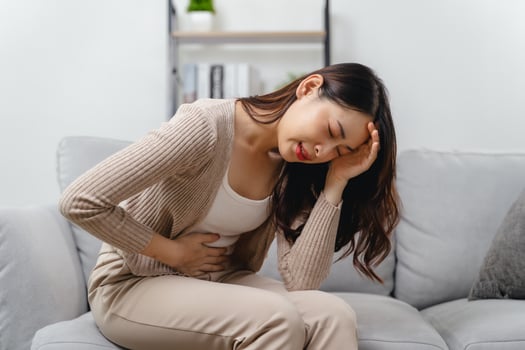 The woman with a stomachache is holding her stomach in pain photo