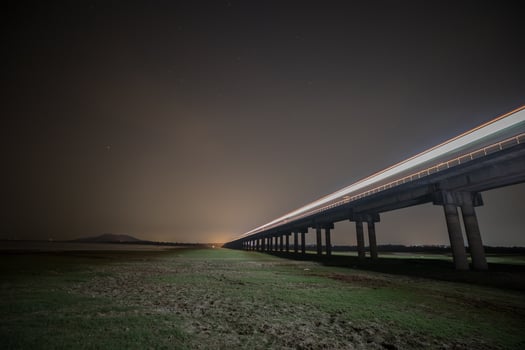 Train is moving on rail at night time with background of star location at thailand photo