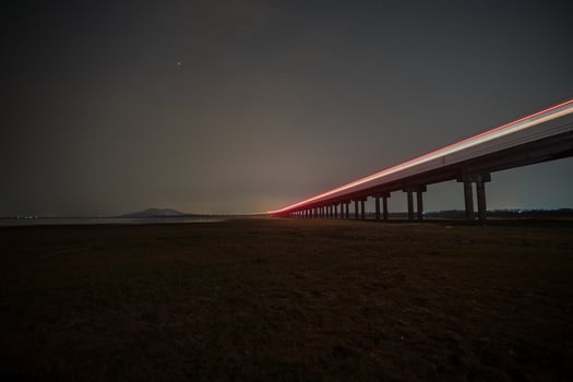Train is moving on rail at night time with background of star location at thailand photo