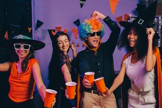 Joyful office Halloween party with coworkers in costumes, celebrating with drinks and laughter, fostering teamwork and festive spirit photo