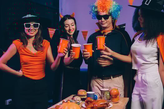 Joyful office Halloween party with coworkers in costumes, celebrating with drinks and laughter, fostering teamwork and festive spirit photo