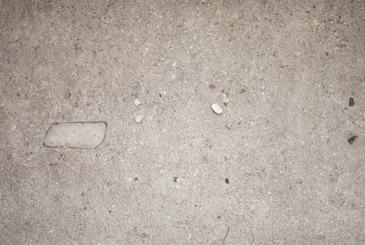 Close-up of plain concrete surface with small stones and rough texture, suitable for backgrounds and construction projects. photo