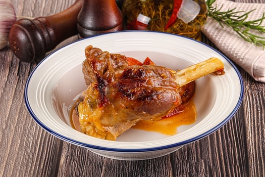Baked lamb shank with vegetables photo