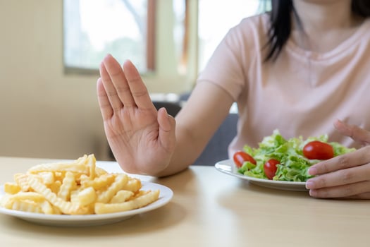 Beauty slim female body confuse French fries. Woman in restaurant achieves weight loss goal for healthy life, crazy about thinness, thin waist, nutritionist. Diet, body shape. photo