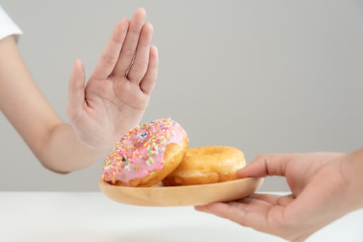 Diet and dieting. Beauty slim female body confuse donut. Woman in exercise clothes achieves weight loss goal for healthy life, crazy about thinness, thin waist, nutritionist. photo