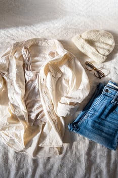 Casual shirt and jeans placed on bed in morning at home. photo