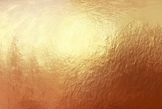 Close-up of textured gold surface with a metallic shine, ideal for use in luxury backgrounds, design, and creative projects. photo