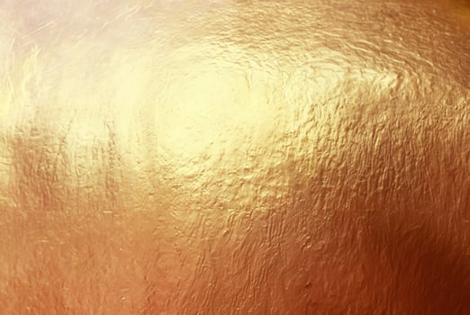 Close-up of textured gold surface with a metallic shine, ideal for use in luxury backgrounds, design, and creative projects. photo