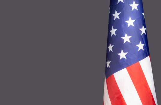 The American flag is on the right side on a gray background photo