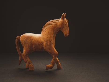 One old wooden horse over on the black background photo