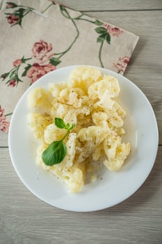 steamed cauliflower in a plate on a wooden table photo