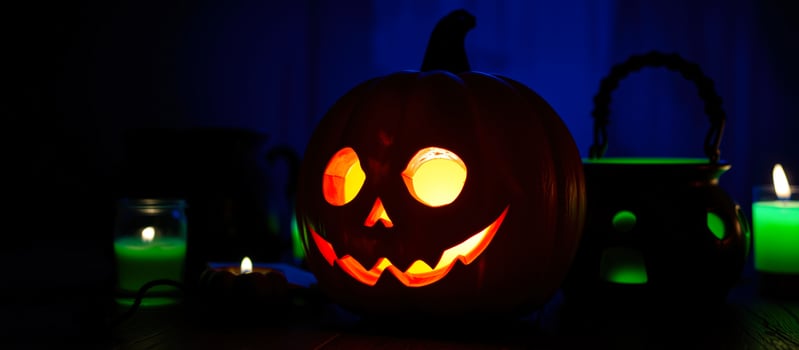 glowing carved pumpkin on a wooden surface photo