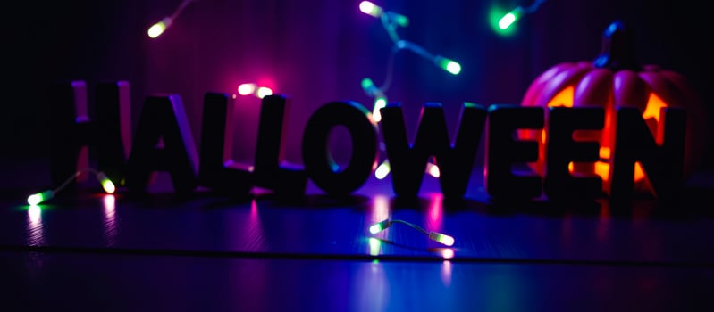 dark moody halloween scene with a carved pumpkin lights photo