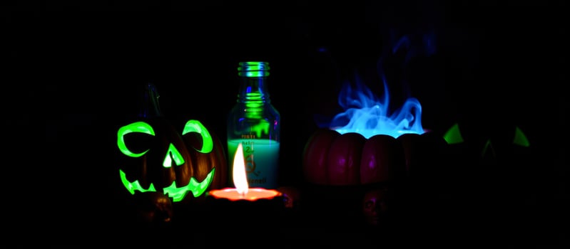 a halloween candle lit up with a pumpkin and a candle photo