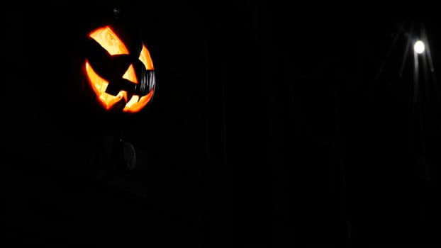 lighted pumpkin against a dark night sky photo