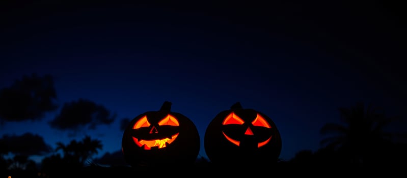 two glowing pumpkins against a night sky photo