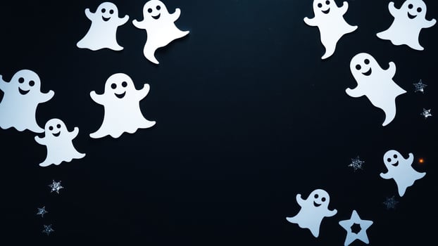 smiling paper ghosts glittering stars on a dark background photo