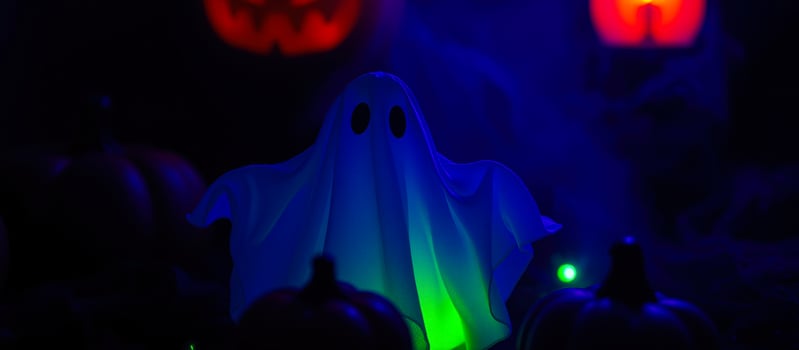 glowing ghost amidst dark pumpkins photo