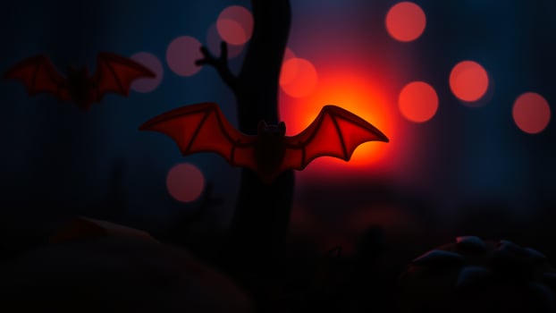 red plastic bat flies against a blurred background lights photo