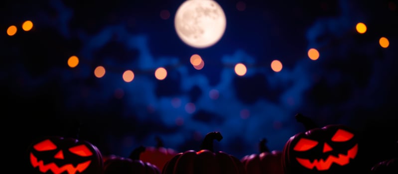 luminous jack-o'-lanterns under a full moon photo