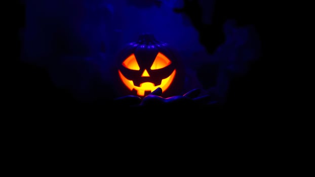 glowing jack-o'-lantern smiles a cloud blue smoke photo