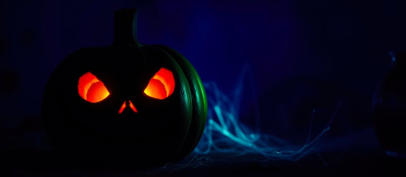glowing pumpkin with eerie blue smoke photo