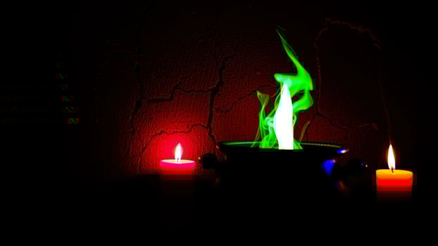 cauldron with a green flame red candles photo