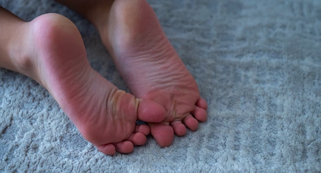 A person's feet on a gray carpet photo