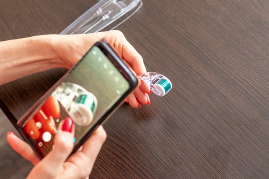 Woman taking a picture of the micro needle skin care derma roller. Concept photo