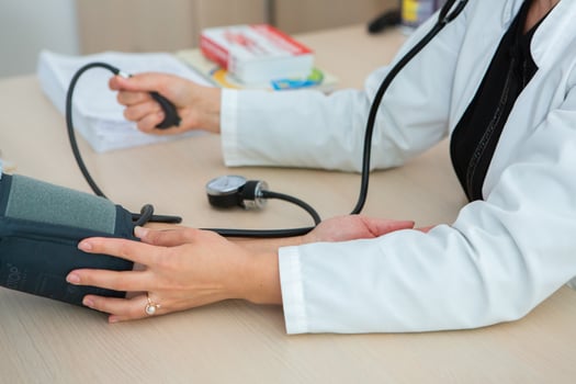 Doctor measuring blood pressure of patient in hospital. Medical and healthcare concept. photo