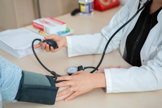 Doctor measuring blood pressure of patient in hospital. Medical and healthcare concept. photo