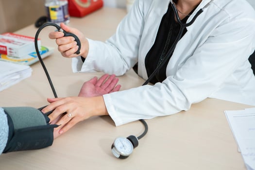 Doctor measuring blood pressure of patient in hospital. Medical and healthcare concept. photo