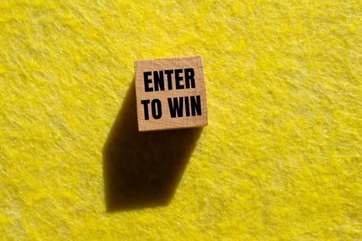 Enter to win message written on wooden cube with yellow background. Conceptual enter to win symbol. Copy space. photo