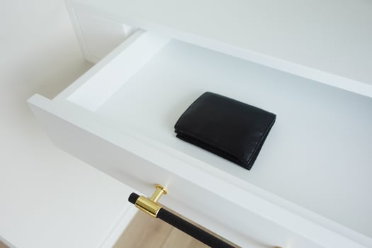 A minimalist black wallet on a white drawer, showcasing a stylish contemporary design photo