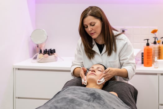 Relaxed woman having cleaning facial treatment in salon photo