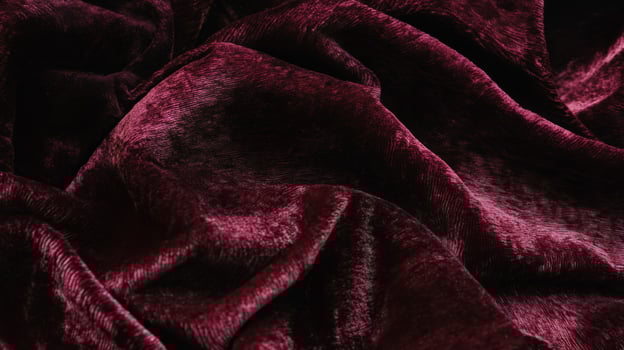 Close-up of a Deep Red Velvet Fabric with Wrinkles and Drapes photo