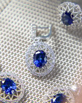 Jewelry set with large blue gemstones sparkling on white background photo