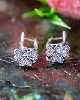 Pair of silver diamond earrings in butterfly shape on labradorite stone photo