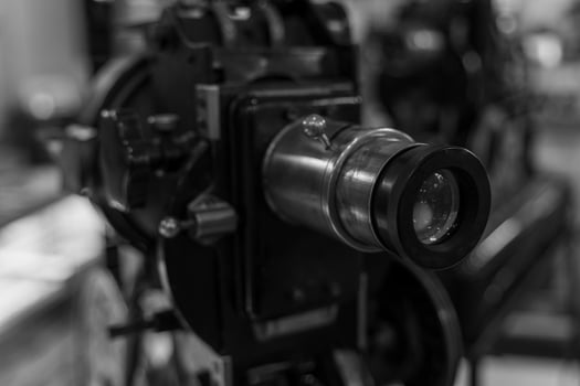 A vintage film projector lens is positioned for viewing, ready to project a classic film photo