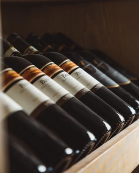 Wine bottles resting on a wooden shelf photo